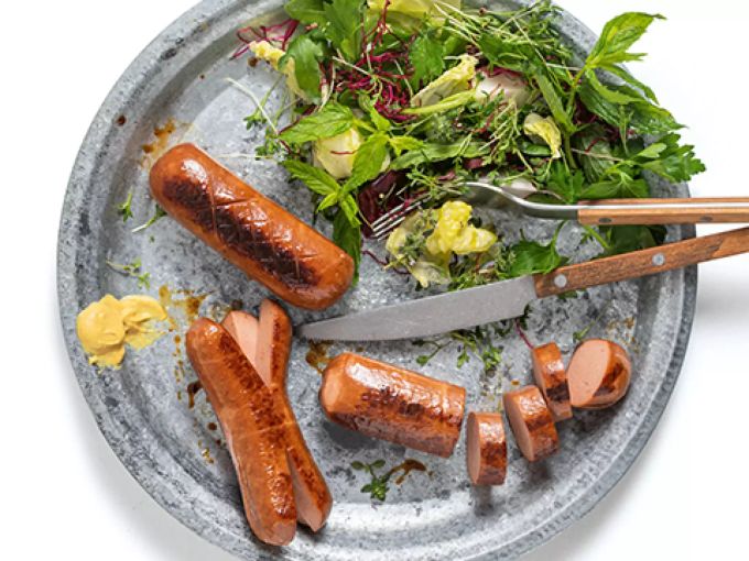 Die V-Love Wurstalternativen der Migros sehen aus wie echte Cervelats. Wurst auf Teller