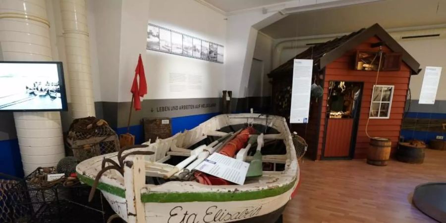 Ein Börteboot und eine Hummerbude (hinten r) sind im Museum Helgoland zu sehen. Foto: Marcus Brandt/dpa