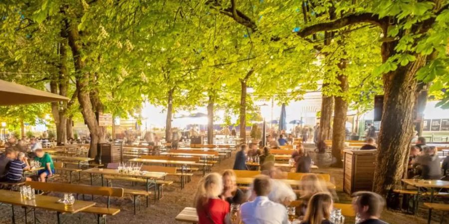Besucher sitzen im Biergarten: Bayern überlegt auch Innen wieder zu öffnen. Foto: Peter Kneffel/dpa
