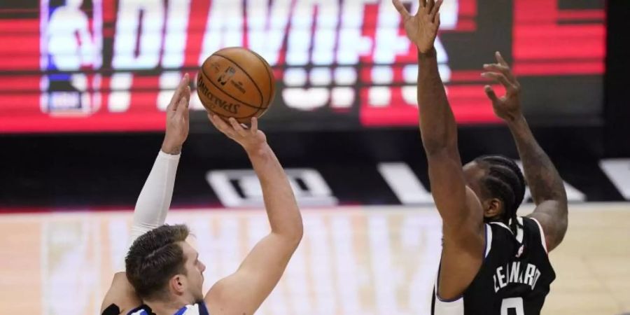 Luka Doncic (l) von den Dallas Mavericks wirft über Clippers-Starspieler Kawhi Leonard. Foto: Mark J. Terrill/AP/dpa