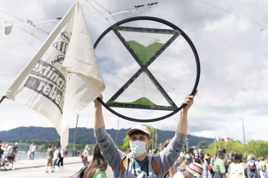 Ein Mann hält während der Protestaktion vom 20. Juni 2020 in Zürich das Logo von Extinction Rebellion in die Höhe.