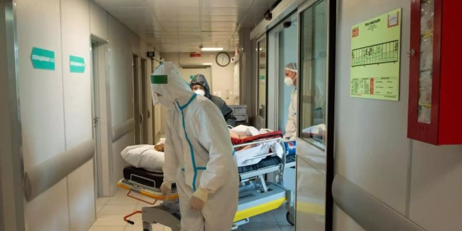 Medizinisches Personal verlegt einen Corona-Patienten auf einer Intensivstation in Moskau. Foto: Denis Grishkin/Moscow News Agency/AP/dpa/Archiv