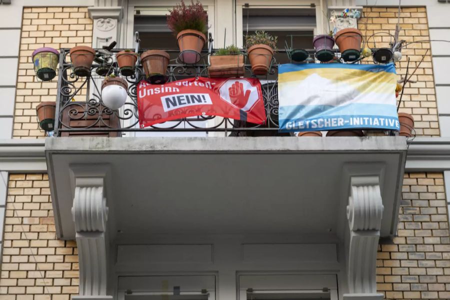 Politische Plakate hängen an einem Balkon.