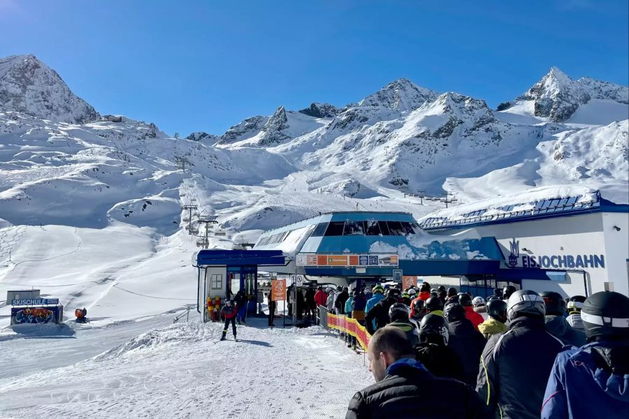 Menschen in Schlange vor Skilift