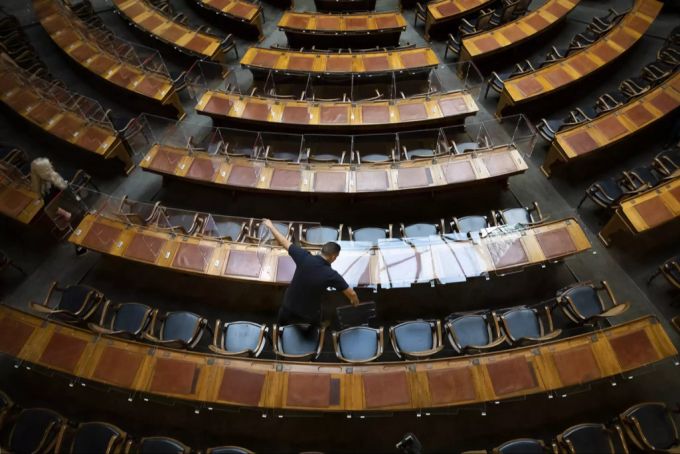 Da im Bundeshaus die Zertifikatspflicht eingeführt wurde, montiert ein Mitarbeiter der Parlamentsdienste die Plexiglasscheiben an den Pulten ab. Covid-19-Gesetz