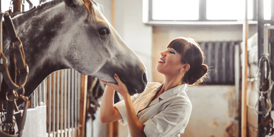 Frau mit Pferd im Stall