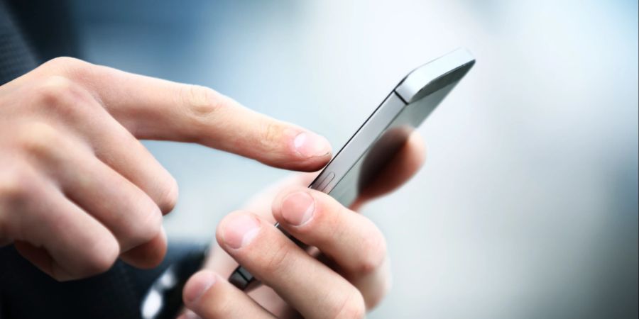 Männerhand hält und bedient smartphone