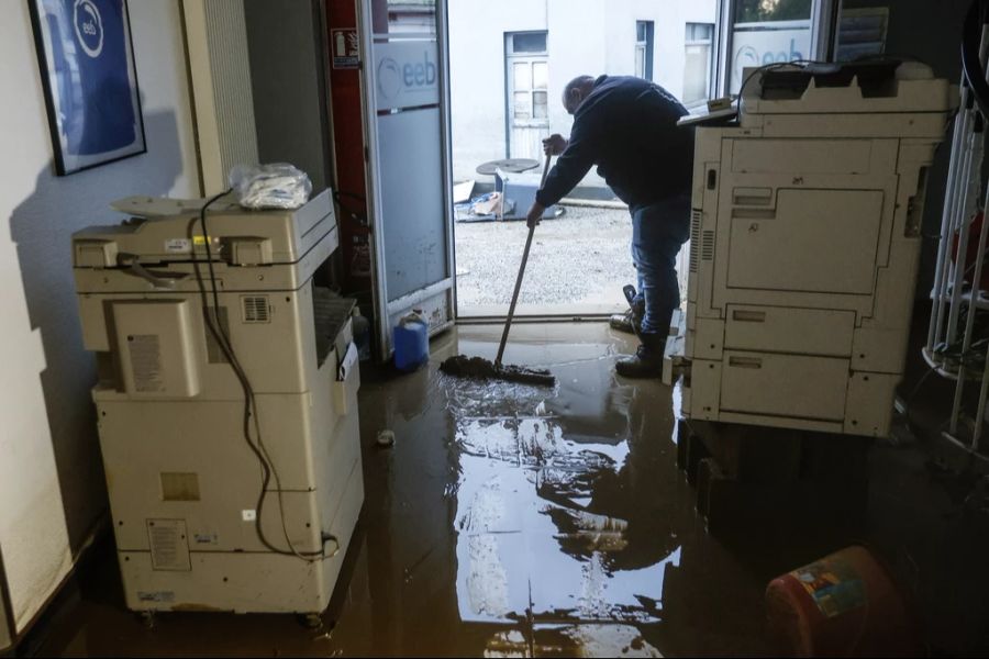 Ein Angestellter des Stromversorgungsunternehmens EEB reinigt einen Tag nach dem Überlaufen der Liane einen schlammigen Boden in Saint-Etienne-au-Mont, Departement Pas-de-Calais, Frankreich.