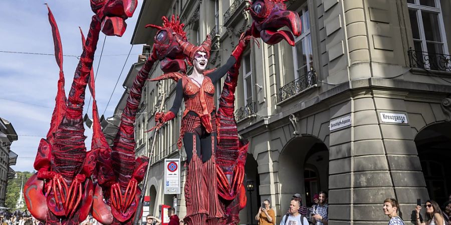 Dinosaurier strömen durch die Gassen an der Eröffnung des 20. Buskers Festival in Bern.