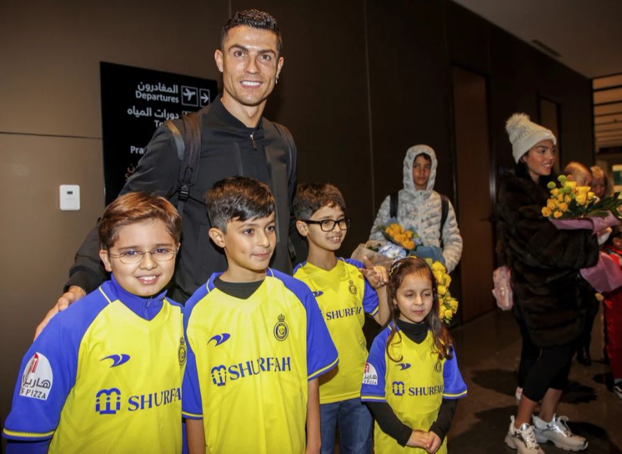 Der Superstar posiert bei seiner Ankunft mit Kindern.