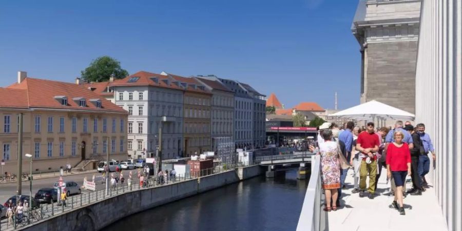 Besucher stehen nach der Eröffnung der James-Simon-Galerie auf der Terrasse. Foto: Soeren Stache