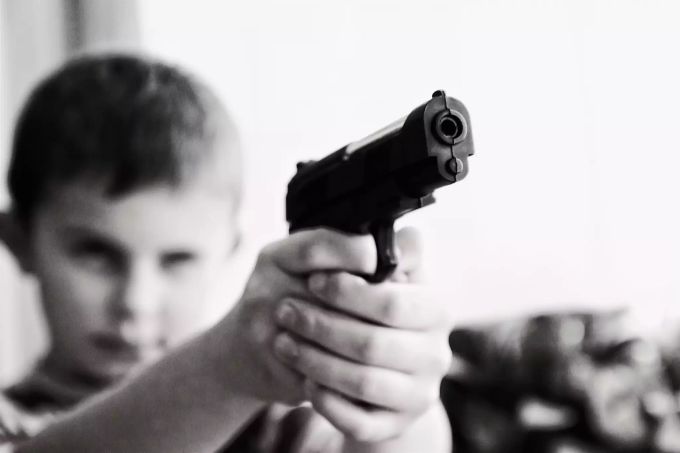 Oft werden auch Kinder Zeugen von Gewalt. Dadurch kann sich ihre Einstellung zu Gewalt verändern. Gewalt Kind Junge Pistole