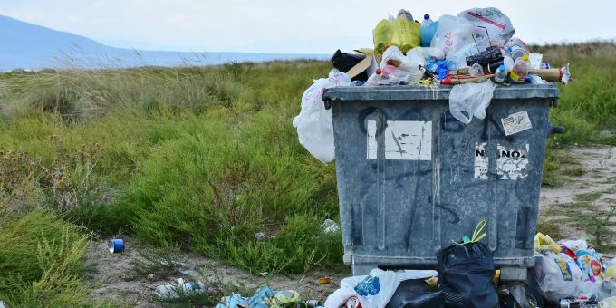 In, um und auf einem Container liegt Müll. Müll