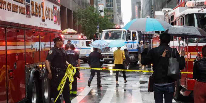 Ein Polizist hält ein Absperrband, um Passanten von dem Unglücksort eines Hubschraubers fernzuhalten. Manhattan Helikopter