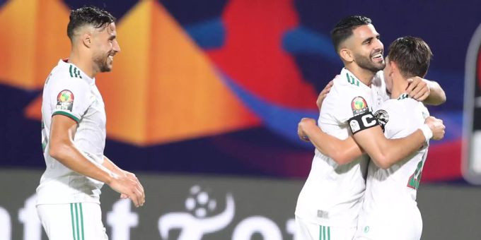 Riyad Mahrez (m), Ismail Bennacer (r) und Youcef Belaïli (l) feiern den Finaleinzug mit Algerien. Youcef Belaïli