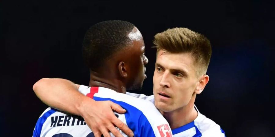 Neuzugang Krzysztof Piatek (r) und Dodi Lukebakio von Hertha umarmen sich nach Spielende. Foto: Soeren Stache/dpa-Zentralbild/dpa
