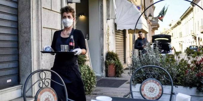 Eine Angestellte eines Restaurants trägt eine Maske. Tessin
