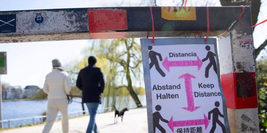 Ein selbstgebasteltes Schild mit der Aufschrift «Abstand Halten». Foto: Christian Charisius/dpa