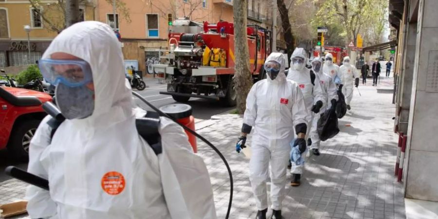Soldaten in Schutzanzügen in Barcelona sind mit Abstand in Richtung eines Seniorenheims für Desinfektionsarbeiten unterwegs. Foto: David Zorrakino/Europa Press/dpa