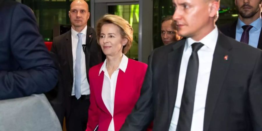 Ursula von der Leyen verlässt von zahlreichen Personenschützern begleitet den Deutschen Bundestag. Foto: Bernd von Jutrczenka/dpa