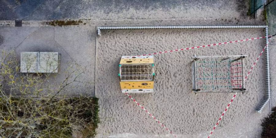 Absperrband ist an einem Klettergerüst für Kinder befestigt. Foto: Swen Pförtner/dpa