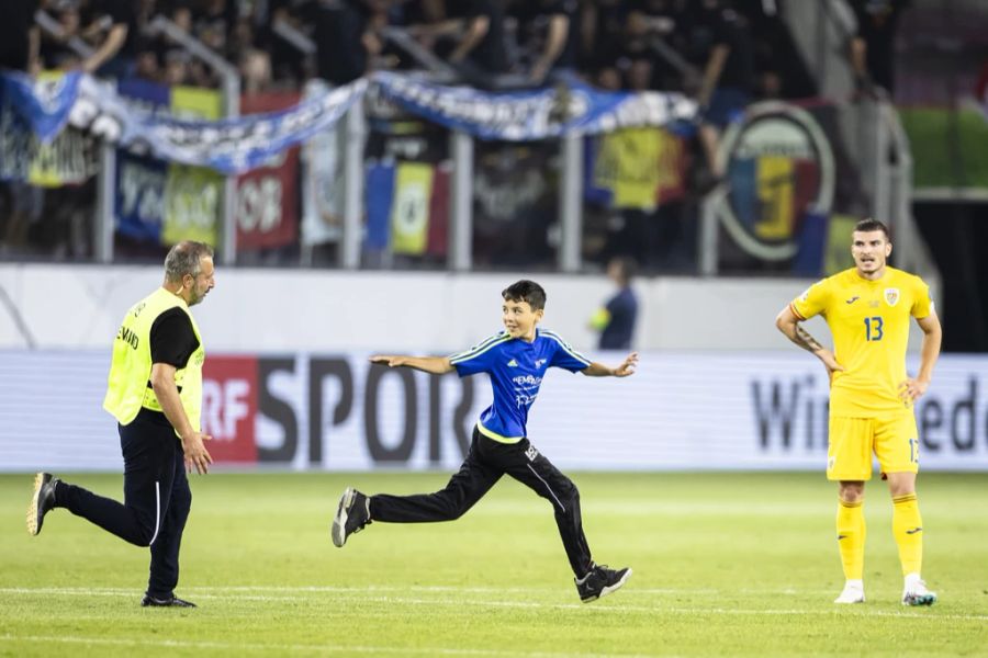 Beim Nati-Spiel gegen Rumänien läuft ein junger Fan auf das Feld und rennt einem Ordner davon.