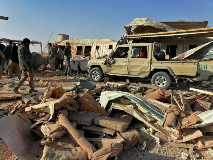 Kämpfer der schiitischen Miliz Kataib Hisbollah begehen ihr Hauptquartier, das durch einen US-Luftangriff zerstört wurde. Bei dem Angriff wurden nach Angaben der vom Iran unterstützten Miliz mindestens 24 Menschen getötet und 50 weitere verletzt. Nach US-Luftangriff Irak