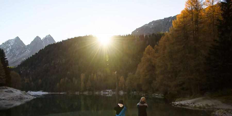 Zwei Jugendliche fotografieren einen Sonnenaufgang: Junge Menschen sollen einen Trend setzen, indem sie klimafreundlich reisen. (Symbolbild)