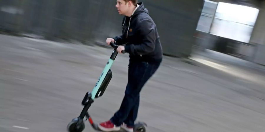 Mann fährt auf elektrischem Tretroller
