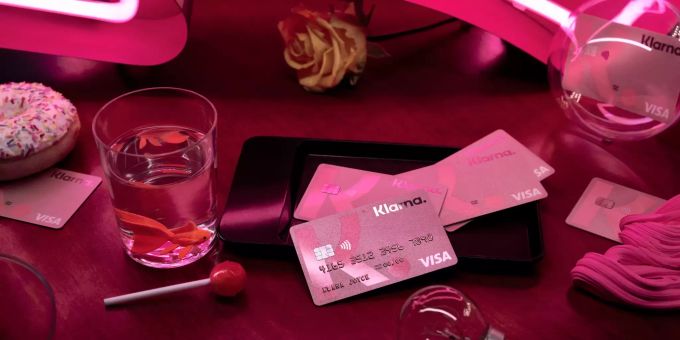 Einige Klarna Cards liegen auf dem Tisch. Mobile Payment klarna