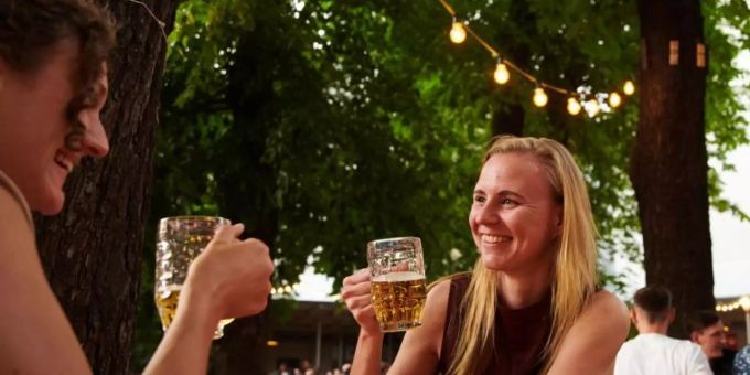 Zwei Frauen trinken ein Bier im Prater Biergarten in Berlin. Foto: Annette Riedl/dpa/Archiv Bier trinken Frauen