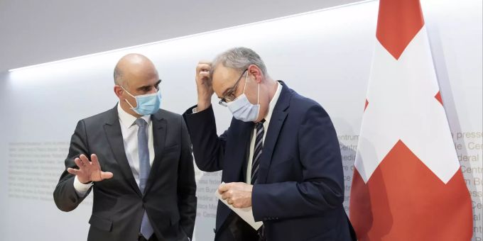Bundespräsident Guy Parmelin, rechts, diskutiert mit Bundesrat Alain Berset am Ende einer Medienkonferenz des Bundesrates zur aktuellen Lage im Zusammenhang mit dem Coronavirus. politik coronavirus