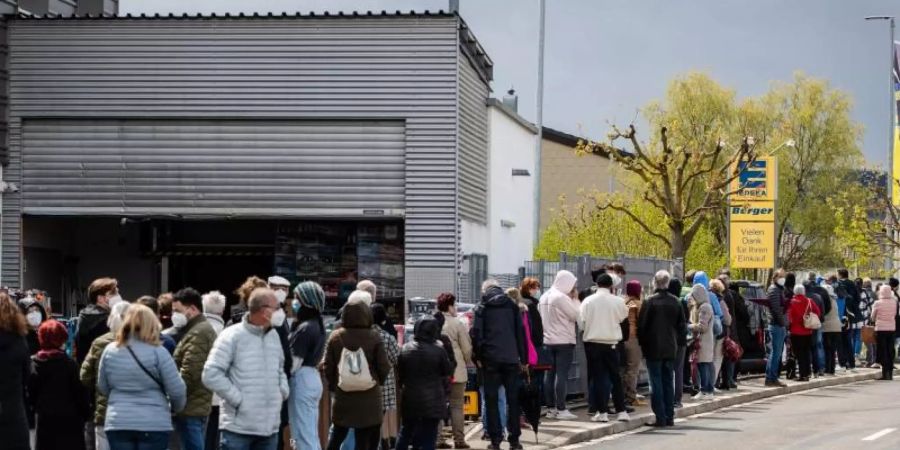 Zahlreiche Menschen stehen an einem Supermarkt Schlange, um dort ohne Termin mit dem Impfstoff Astrazeneca geimpft zu werden. Foto: Christoph Schmidt/dpa