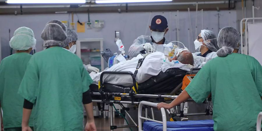 dpatopbilder - Mitarbeiter versorgen in einem Feldlazarett in Santo Andre einen Corona-Patienten. Foto: Vanessa Carvalho/ZUMA Wire/dpa