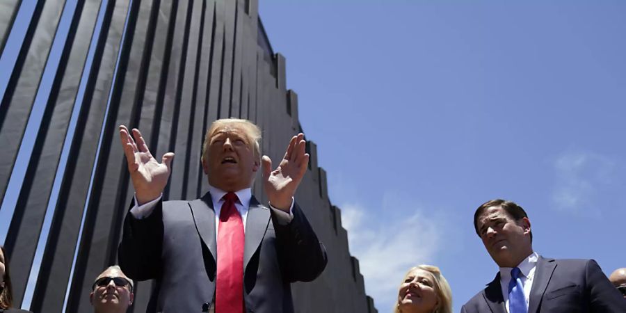 ARCHIV - Donald Trump, Präsident der USA, spricht 2020 bei einem Rundgang an einem Abschnitt der Grenzmauer zwischen Mexiko und den USA. (Archivbild) Foto: Evan Vucci/AP/dpa