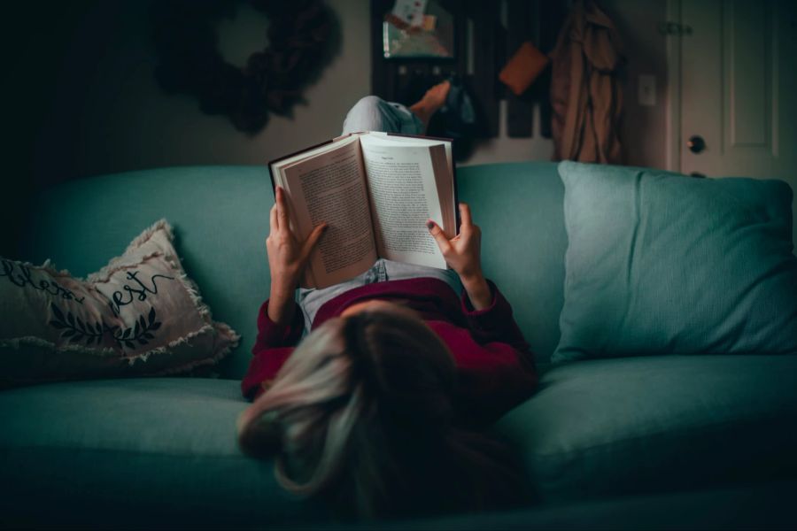 Frau liest auf Sofa