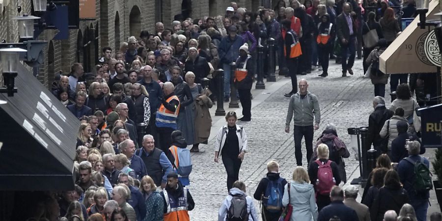 Menschen stehen in einer Schlange, um der verstorbenen Königin Elizabeth II. während der Staatsaufbahrung in der Westminster Hall die letzte Ehre zu erweisen. Foto: Christophe Ena/AP/dpa