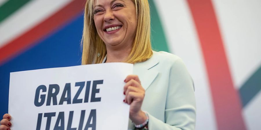 dpatopbilder - Giorgia Meloni, Vorsitzende der rechtsradikalen Partei Fratelli d'Italia (Brüder Italiens), hält ein Schild mit der Aufschrift «Grazie Italia» («Danke Italien») während einer Pressekonferenz in der Wahlkampfzentrale ihrer Partei. Italien hat am Sonntag, 25.09.2022, ein neues Parlament gewählt. Foto: Oliver Weiken/dpa