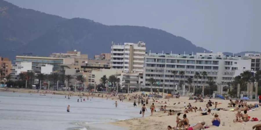 Menschen sonnen sich am Strand von Arenal auf Mallorca. Noch vor den Sommerferien soll die Reisefreiheit in der EU weitgehend zurückkehren. Foto: Clara Margais/dpa