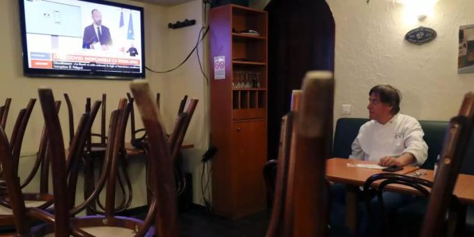 Es war einmal: Ein Restaurantbesitzer schaut sich in Paris auf einem Nachrichtensender eine Fernsehansprache des französischen Premierministers Philippe an. Restaurant Paris