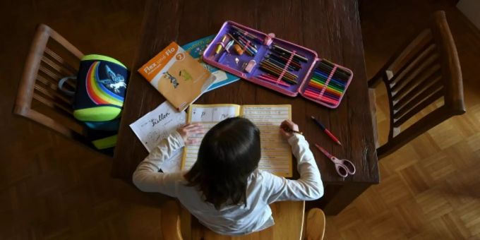 Schulkind beim Homeschooling am heimischen Esstisch Schulkind beim Homeschooling am heimischen Esstisch