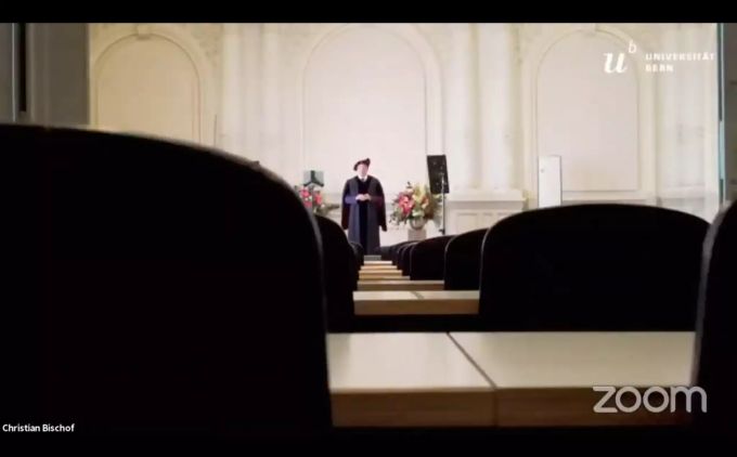 Der Dekan der Universität Bern hält eine Rede vor leeren Tischreihen. Dekan