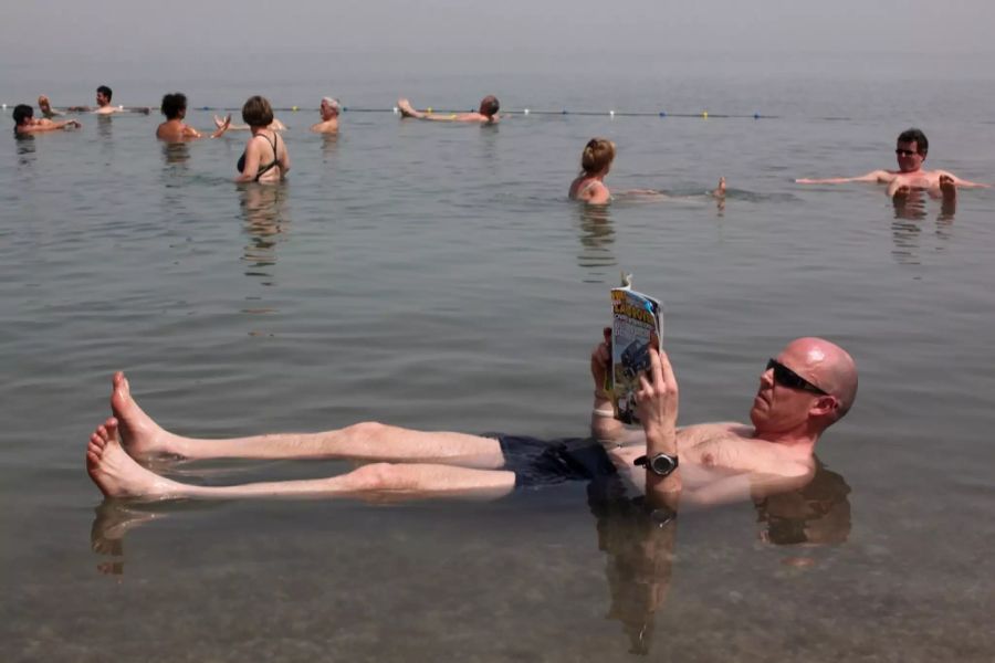 Ein Tourist badet im Toten Meer.