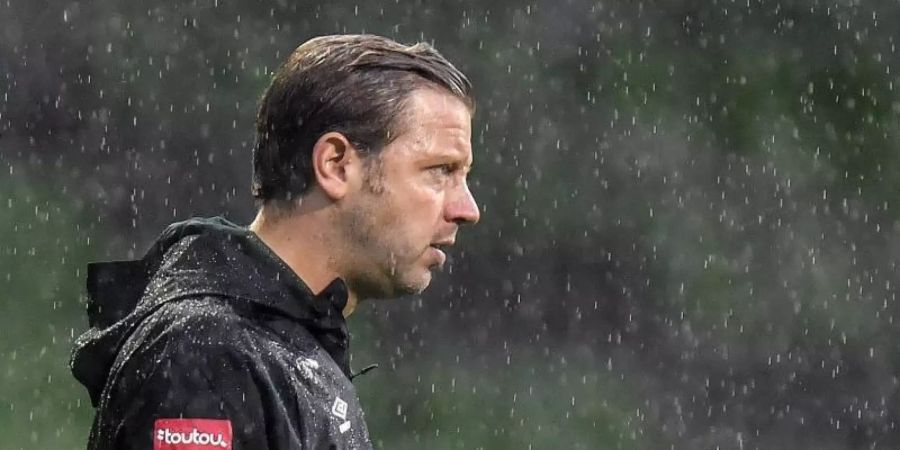 Bremens Cheftrainer Florian Kohfeldt steht im Regen. Foto: Martin Meissner/AP POOL/dpa