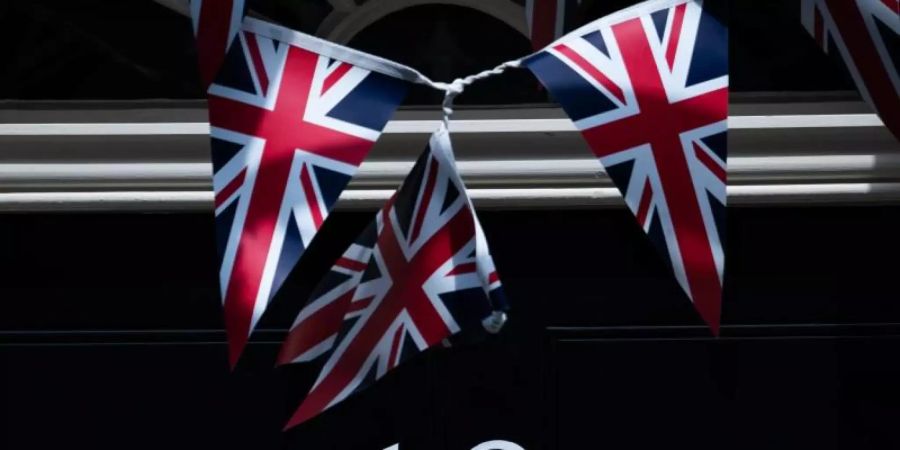 Fähnchen vor der Tür der 10 Downing Street. Aus Protest gegen das Verhalten des britischen Regierungsberaters Cummings ist Staatssekretär Douglas Ross zurückgetreten. Foto: Aaron Chown/PA Wire/dpa
