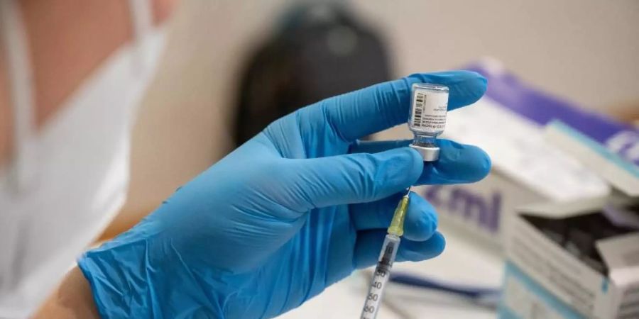 Die Mitarbeiterin eines mobilen Impfteams zieht eine Spritze mit dem Corona-Impfstoff auf. Foto: Sebastian Gollnow/dpa