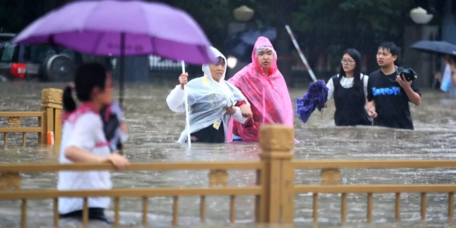 Auch im fernen Ausland prägen Extreme das Wetter: Menschen waten im chinesischen Zhengzhou durch eine überflutete Strasse.