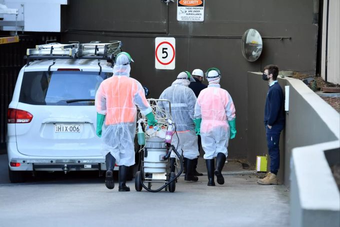 Reinigungskräfte vor einem Gebäude in Sydney, deren Bewohner in Isolation sind. Coronavirus outbreak in Sydney