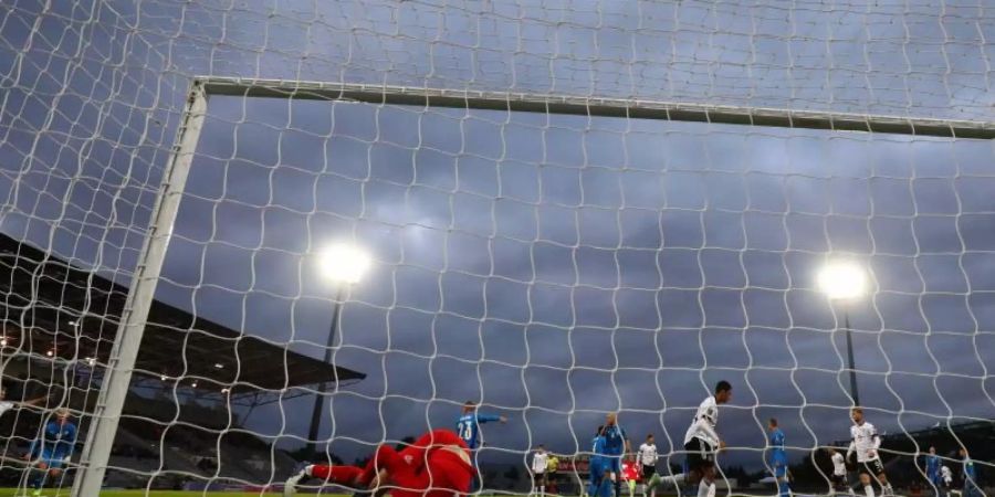 Der Ball liegt nach dem Schuss von Leroy Sané (nicht im Bild) zum 0:3 im Tor von Islands Torwart Torwart Hannes Halldorsson (l). Foto: Christian Charisius/dpa