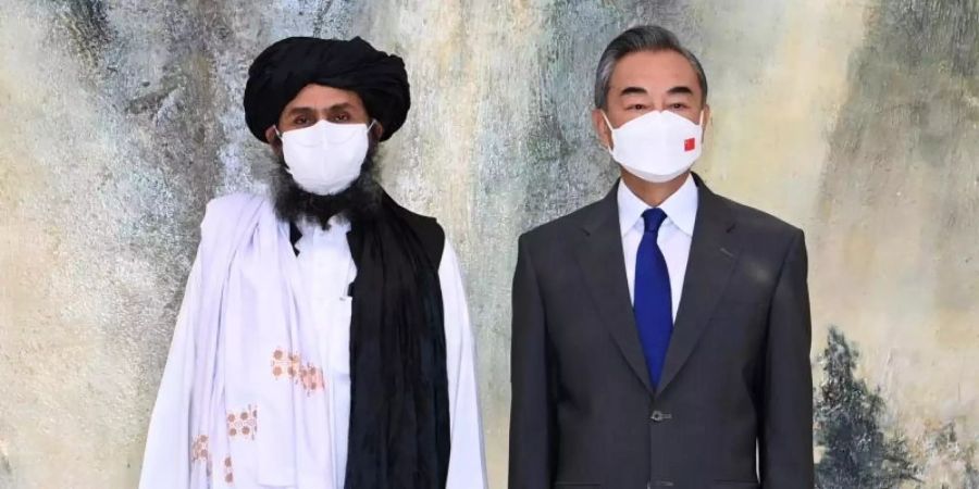 Chinas Aussenminister Wang Yi (r) neben einem Führer der Taliban. Foto: Li Ran/XinHua/dpa